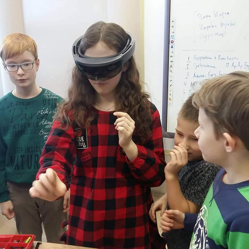 Children use a VR headset to play a game.